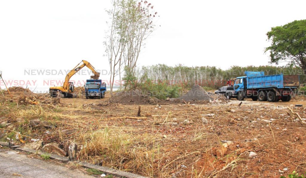 An excavator clears an area along Kings Wharf, San Fernando as part of the waterfront development project. Udecott has announced DravoSA Ltd, a firm from Madrid, Spain has been awarded the contract to reclaim 3.8 hectares of land. PHOTOS BY LINCON HOLDER