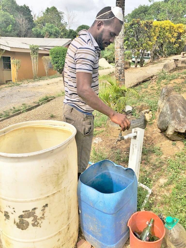 File photo: A villager opens a standpipe in Poonah Village, Williamsville to find that there is no water. PHOTO BY SEETA PERSAD