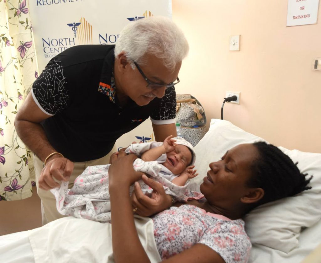 A CUTIE: Newborn Yara-Lee has the attention of Health Minister Terrence Deyalsingh while her mother Chevonn Parks is all smiles at the Port of Spain general hospital yesterday.   PHOTO BY KERWIN PIERRE