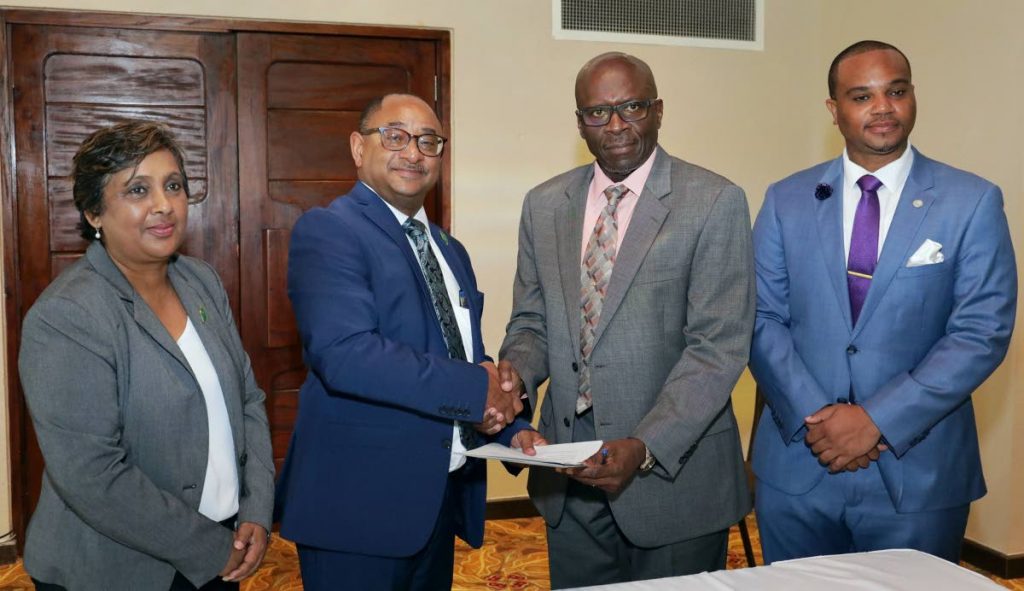 (left) Chairman of the Environmental Management Agency Nadia Gyan and (extreme right) THA Secretary of the Division of Infrastructure, Quarries and the Environment, Councillor Kwesi Des Vignes looks on as (seated left) EMA managing director Hayden Romano and THA Chief Administrator Raye Sandy  signs an MOU. 