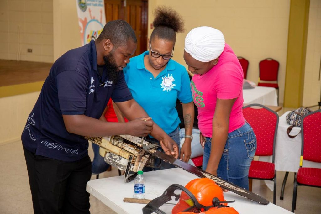 These women learn how to operate a chainsaw at a disaster preparedness and management workshop last week. PHOTO BY DSYA THA