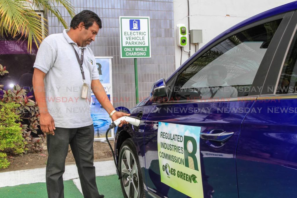 Regulated Industries Commission (RIC) office courier, Daniel Ramsepaul demonstrates how to charge the company’s electric vehicle outside the RIC’s Wrightson Road, Port of Spain office. Members of the public charge their vehicles at the charging station. PHOTO BY JEFF K MAYERS