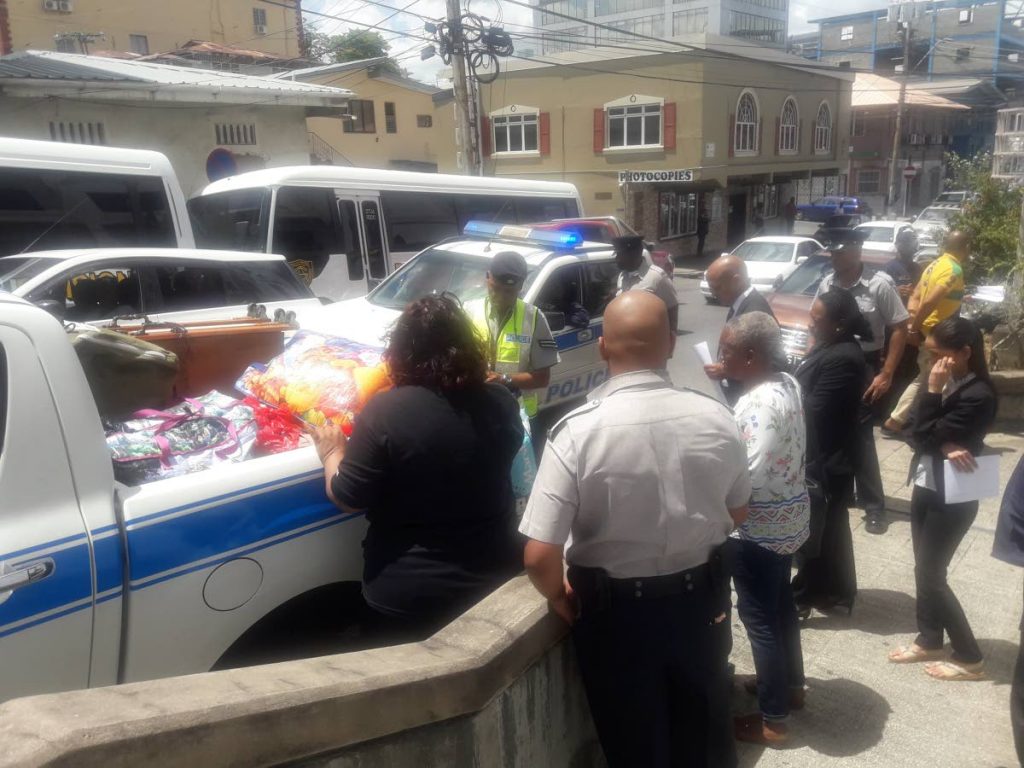 Magistrate, prosecutor and police inspect a vendor's goods outside San Fernando High Court yesterday