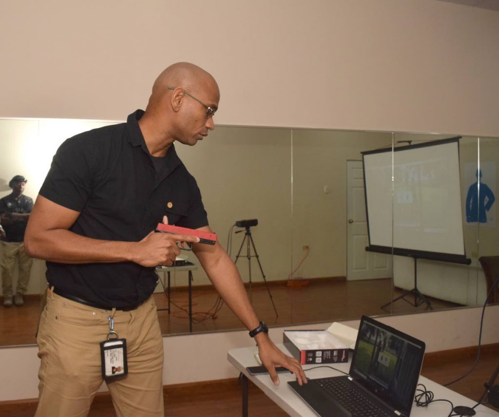 Dirk Barnes demonstrates the imarksman sport simulator used as part of training for all his security personnel. Photo by Vidya Thurab