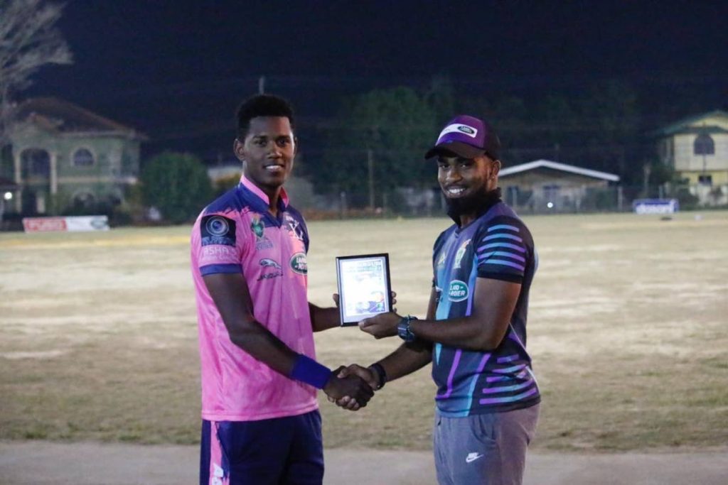 Akeal Hosein (left) collecting his Man of the Match award from fellow TT player Bryan Charles.