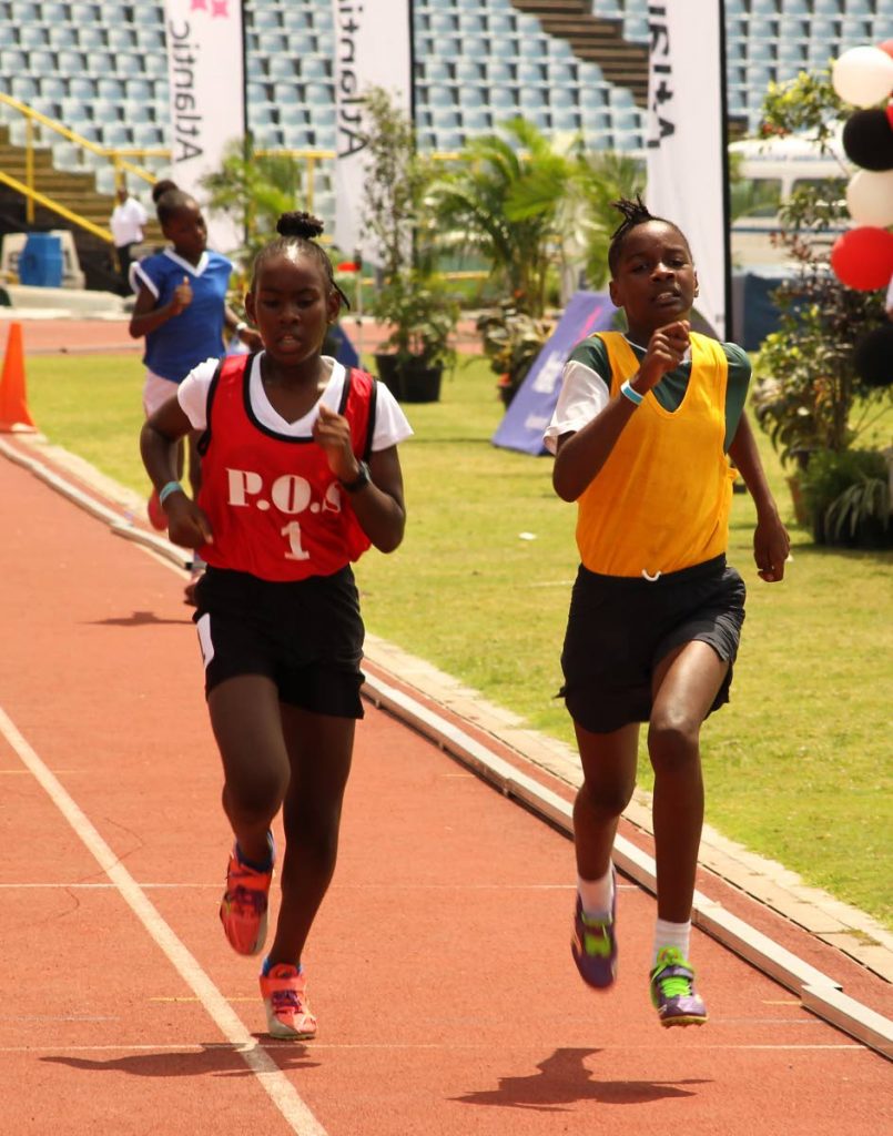 This pair of runners go head-to-head to the finish line in the girls open 1,500 metres yesterday. 