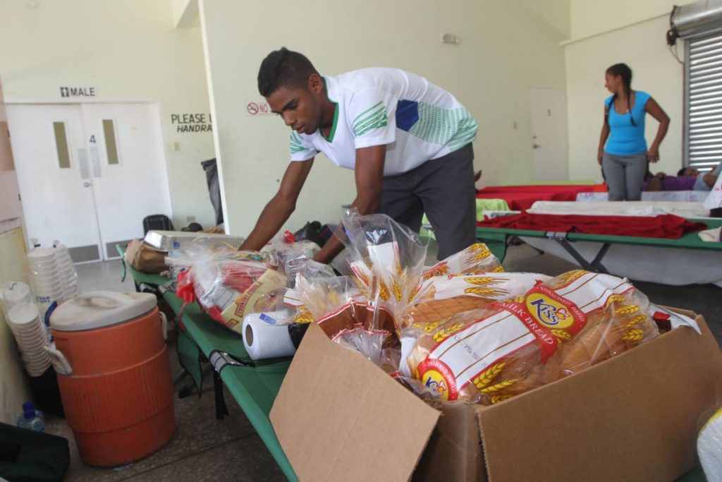 A man examines the food items dropped off at Irwin Park Sporting Complex on Thursday where medical care was being given to the Venezuelans who had arrived illegally on Wednesday. PHOTO BY LINCOLN HOLDER
