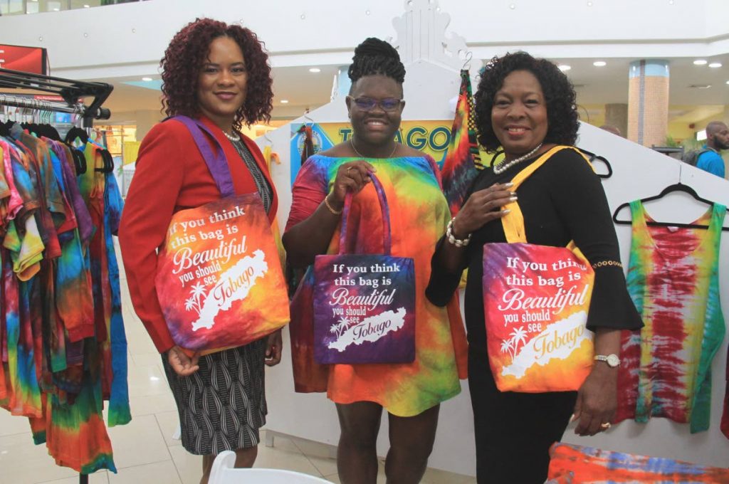 BAG LADIES: Minister of State in the Office of the PM Ayanna Webster-Roy, Sherraine’s Tie Dye designer Kishawna Sebro and THA Secretary for Community Development Marslyn Melville-Jack show off hand bags made by Sebro 