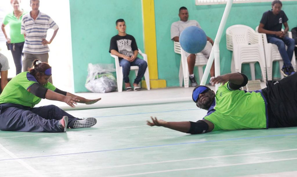 Ako Moosai (right) and Asha Lall from Team Titans Goalball Club save a shot during an exhibition match against Northern Royalties at the Paragon Sports Club, Debe yesterday. 