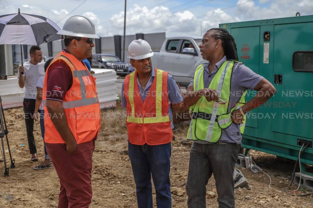 From left: Navin Ramsingh, director of the Highways Division, Minister of Works and Transport Rohan Sinanan, and PURE programme director Hayden Phillip in talks during a demonstration of the Government's new culvert replacement method on the Solomon Hochoy Highway, Freeport, Sunday. JEFF K MAYERS