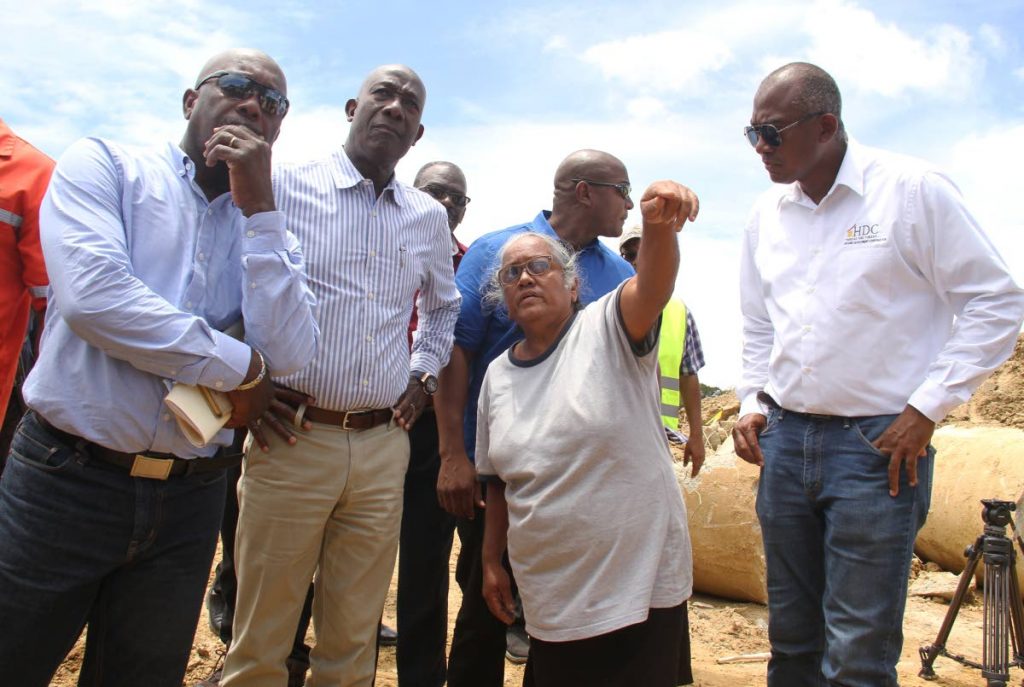 Prime Minister Dr Keith Rowley listens to Esther Freeman, a resident of Greenvale during a tour of the area on April 3. Also listening are HDC chairman Newman George, left, and managing director of HDC Brent Lyons. PHOTO BY AYANNA KINSALE

