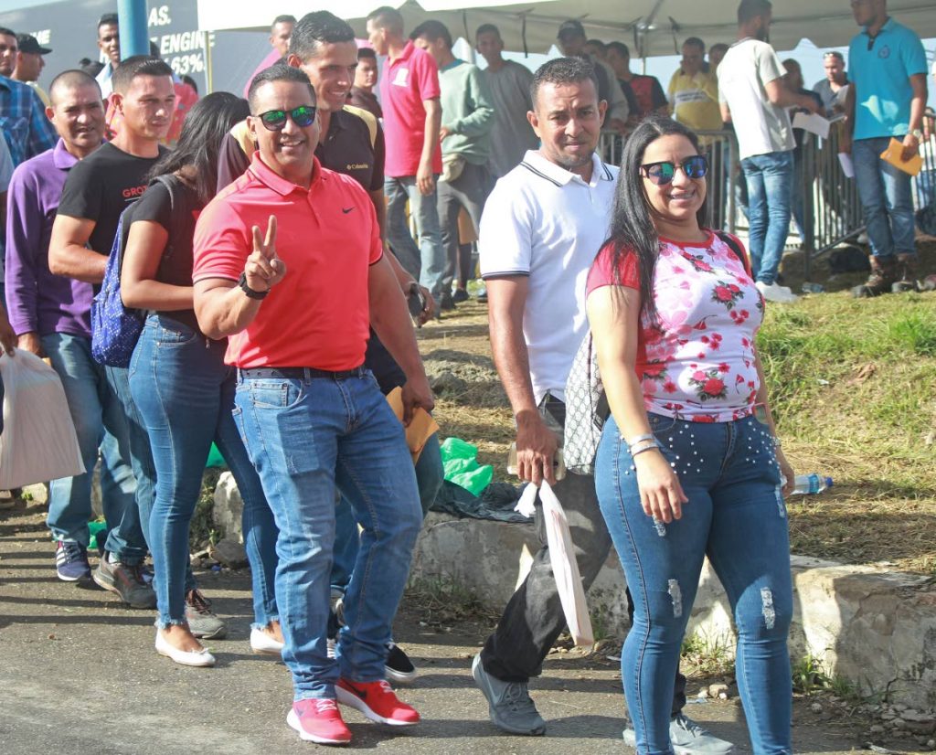 File photo: Venezuelans smile as they walk into the Achievors Banquet Hall at Duncan Village in San Fernando to register. 

 PHOTO BY CHEQUANA WHEELER