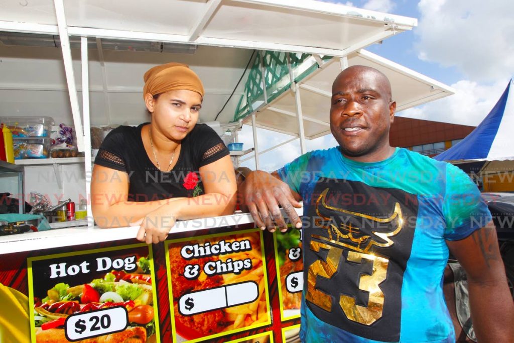 Former Petrotrin temporary worker now food truck owner, Obawole Biddeau, 32 and his Venezuelan girlfriend Hecdymar Dominguez with their food truck outsideAchievors Banquet Hall San Fernando as the regsitration process is ongoing for Venezuelan nationals living in Trinidad.

Photo: Lincoln Holder
