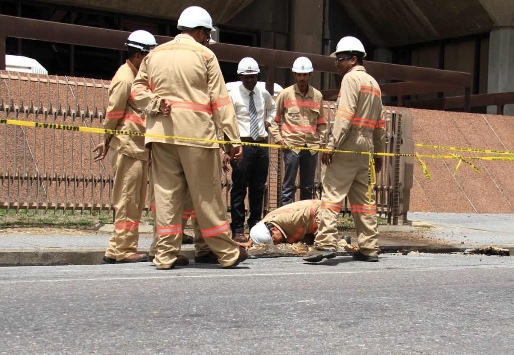 T&TEC general manager Kelvin Ramsook takes a look at the damage done to the road after there was an explosion at the corner of Duke and Abercromby Street last Friday.