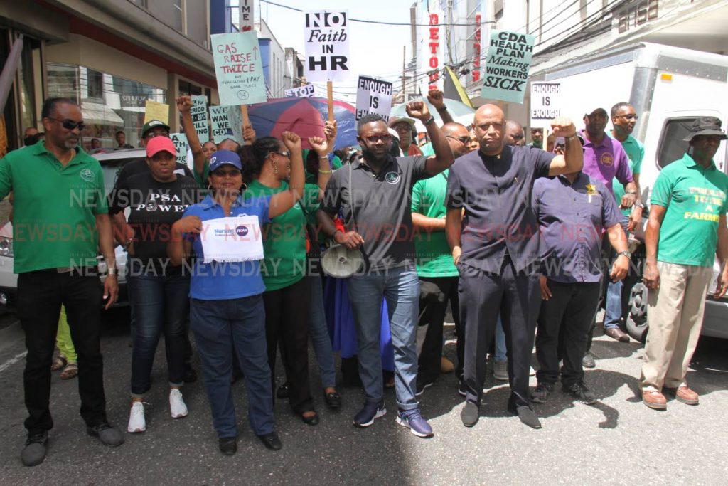 PSA President Watson Duke, centre, and OWTU President Ancil Roget, second from right, march through Port of Spain along with NATUC members at a labour rally on Friday. PHOTO BY ANGELO MARCELLE