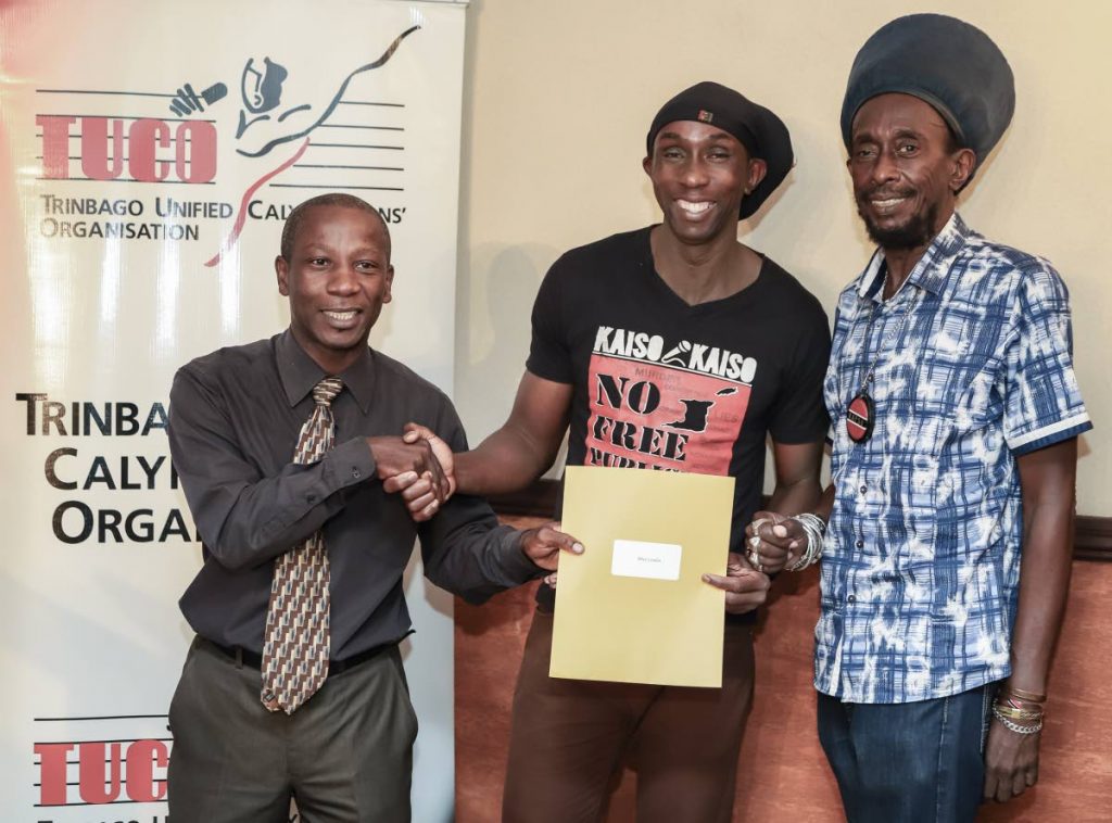WELL DONE: Senior Business Development officer Ivan Thomas, left, presents the People's Choice cheque to winner Brian London while TUCO head Lutalo “Brother Resistance” Masimba looks on at the Queen's Park Oval last Friday. 