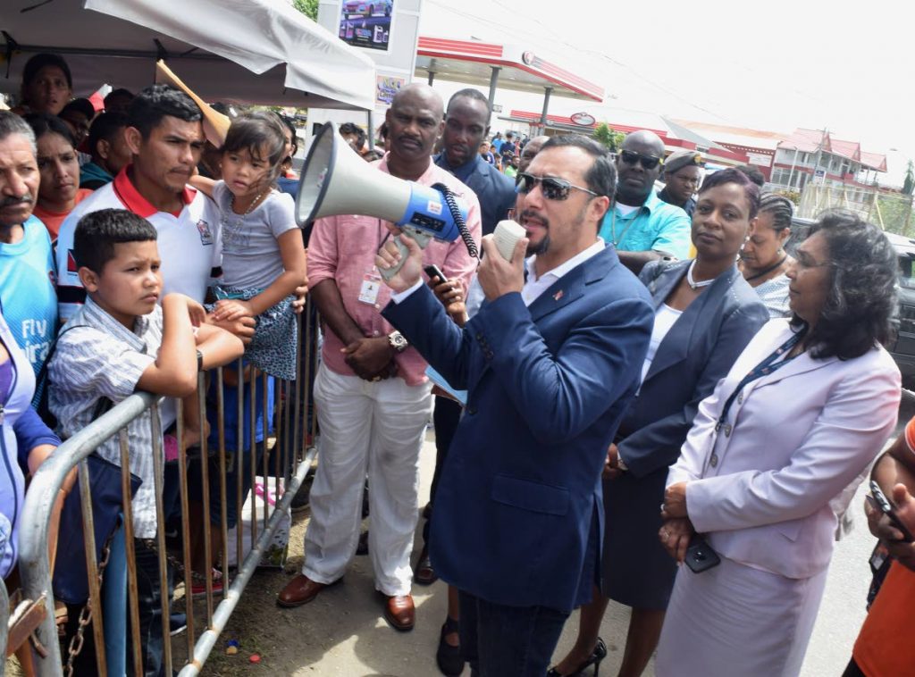 File photo: National Security Minister Stuart Young reassures Venezuelans lined up outside Achievors Banquet Hall that they will be registered at the Duncan Village, San Fernando centre on June 11, 2019