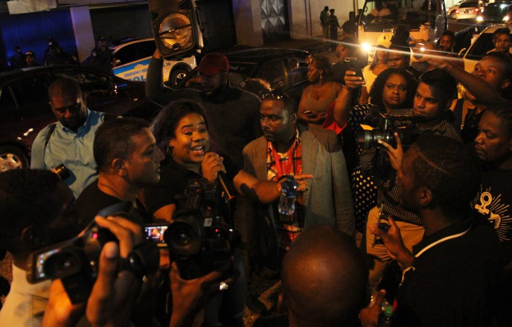 Kia Hosein addresses supporters during a protest outside Queen’s Park Oval, Port of Spain on June 13 under the watch of  plainclothes officers. PHOTO BY AYANNA KINSALE 