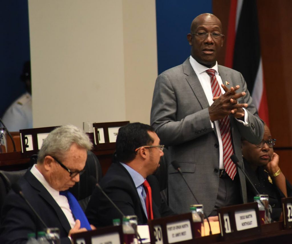 Prime Minister Dr Keith Rowley, with Finance Minster Colm Imbert, left, and National Security Minister Stuart Young beside him addresses Parliament on Friday. PHOTO BY KERWIN PIERRE