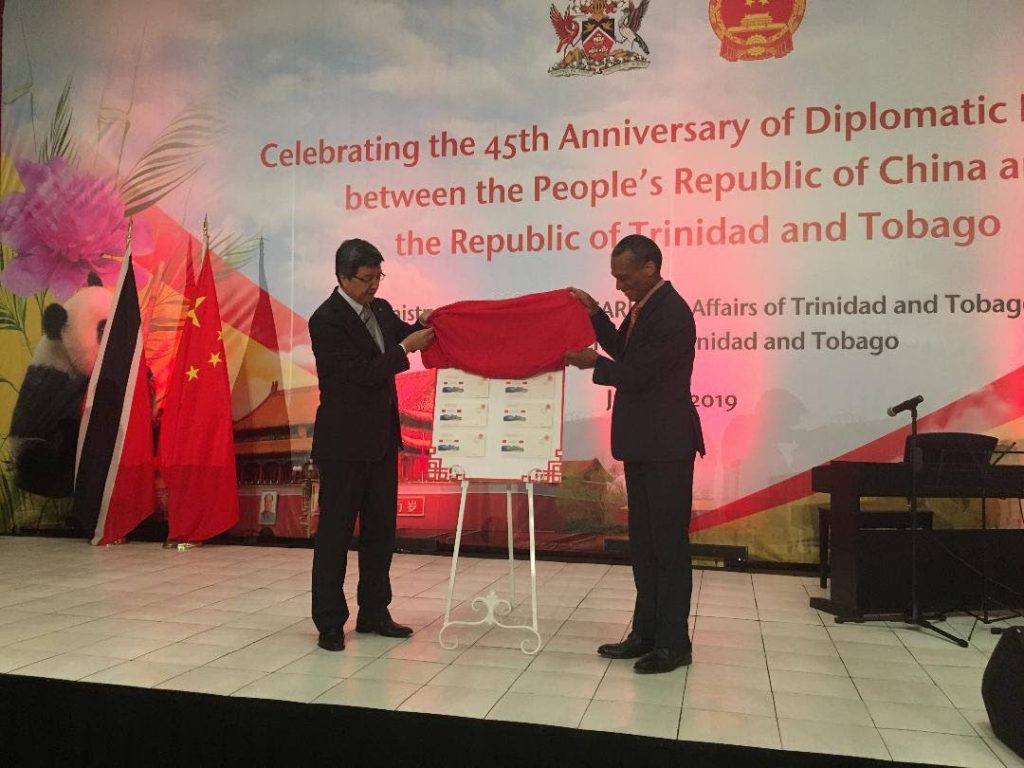 Chinese Ambassador Song Yumin and Foreign Affairs Minister Dennis Moses unveil a commemorative stamp feature the National Academy of Performing Arts Port of Spain campus to celebrate 54 years of bilateral relations between TT and China.