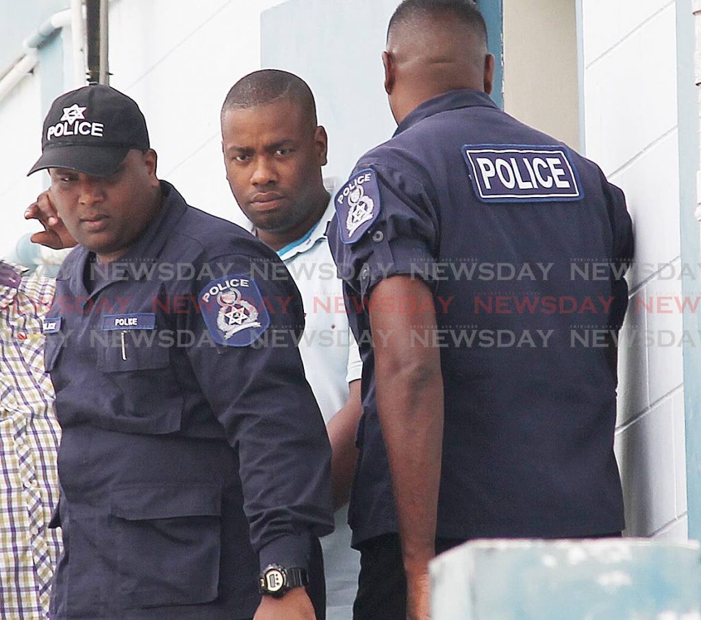 Special reserve police officer (middle) Akeem James being escorted to the Rio Claro court house to appear before a Princes Town magistrate to answer charges of raping and kidnapping a Venezuelan woman on November of 2018.

Photo: Lincoln Holder
