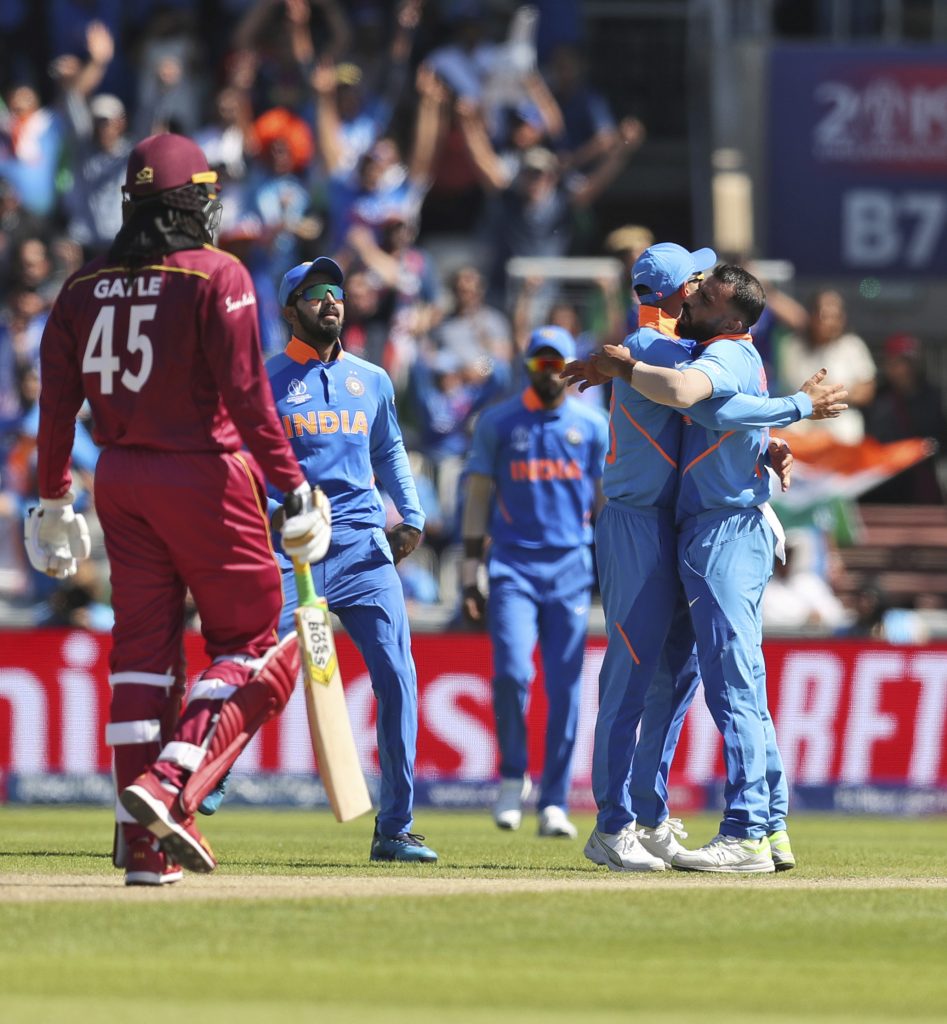 India's Mohammed Shami, right, celebrates with captain Virat Kohli after taking the wicket of West Indies' Chris Gayle during the Cricket World Cup match between India and West Indies at Old Trafford in Manchester, England, Thursday, June 27, 2019. (AP Photo/Jon Super)