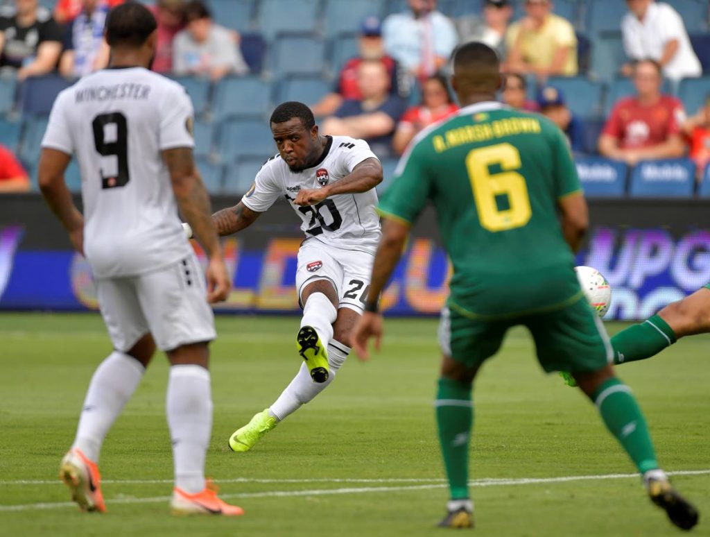 Jomal Williams (C) of TT shoots on goal as teammate Shahdon Winchester (L)  and Ronayne Marsh-Brown of Guyana look on during the Concacaf Gold Cup Group D match on Wednesday at Children’s Mercy Park in Kansas City, Kansas.