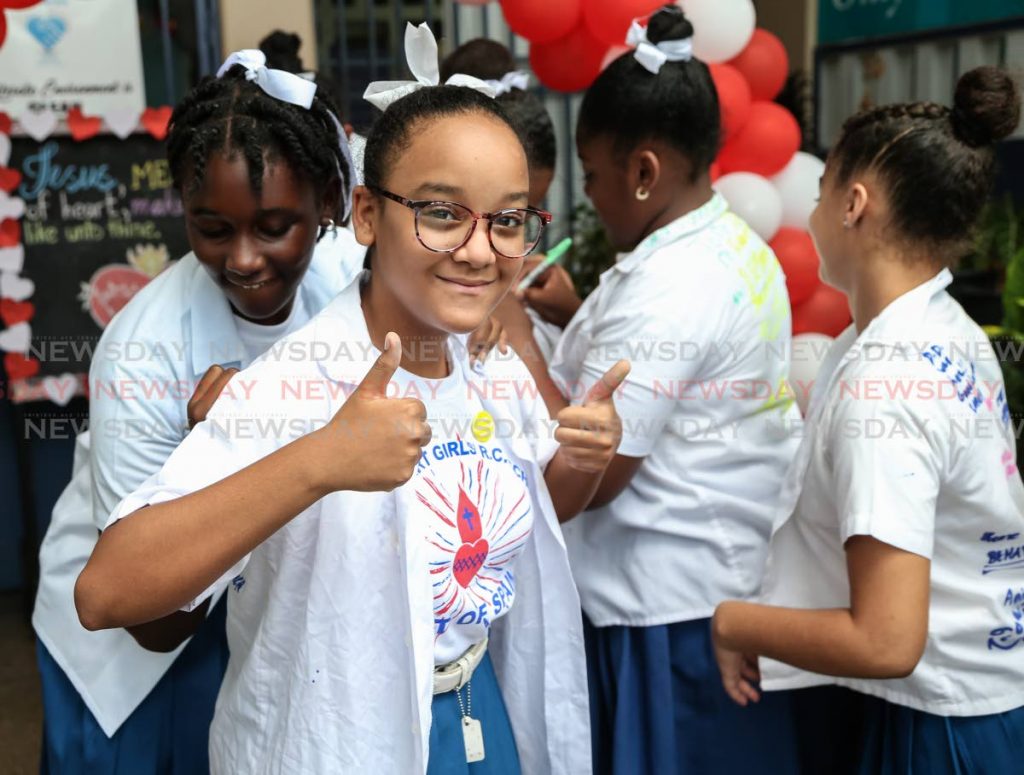 

Ava Marie Dyer has her shirt signed by a friend to celebrate their last day as schoolmates of Sacred Heart Girls RC at MovieTowne, Port of Spain after SEA results on Friday. Dyer passed for Holy Name Convent. 
PHOTOS BY JEFF MAYERS