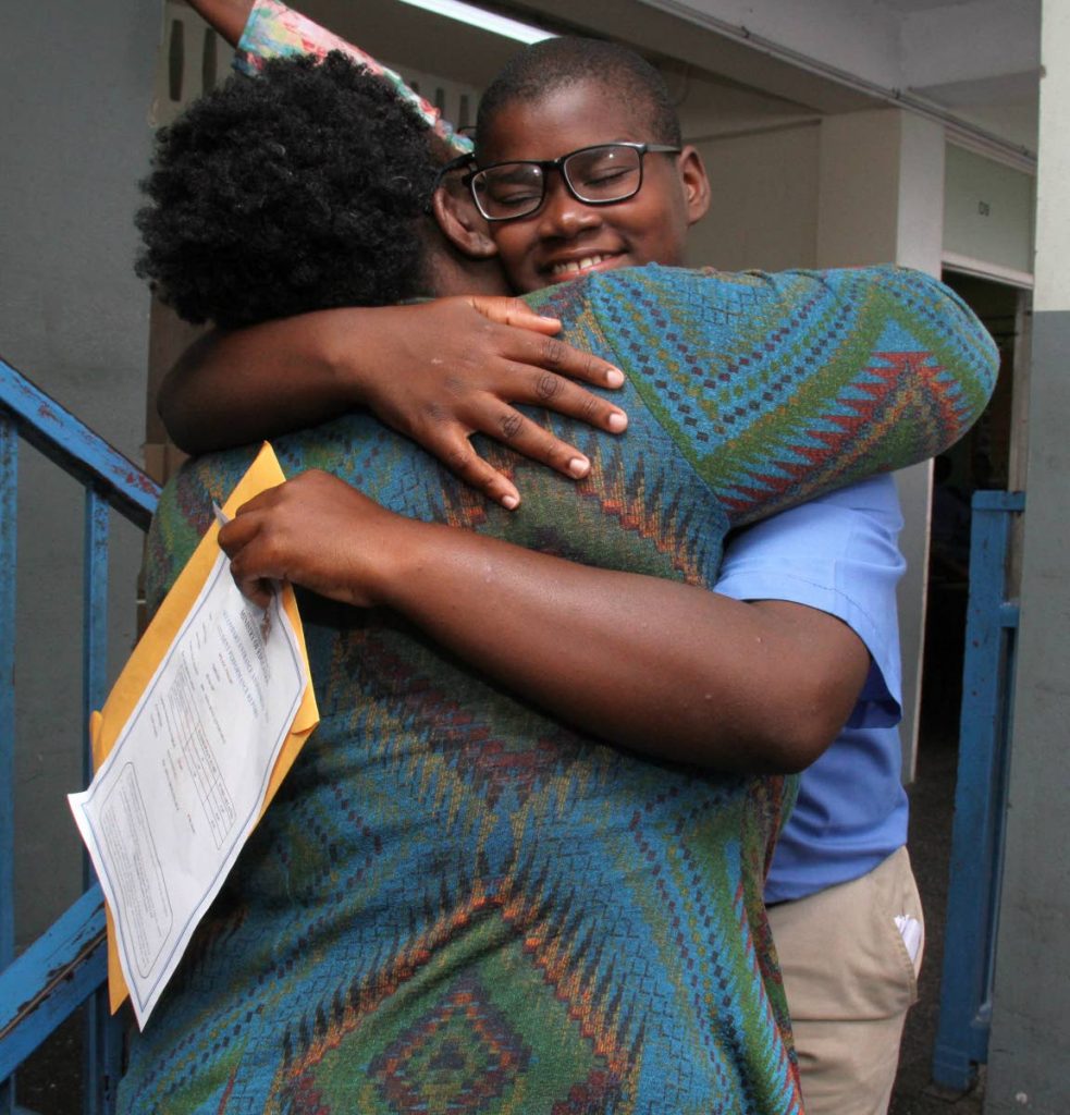 J’Maurc Wilson, of Arima Boys Government Primary School, gets a big hug after he passed for Holy Cross College. PHOTO BY ANGELO MARCELLE