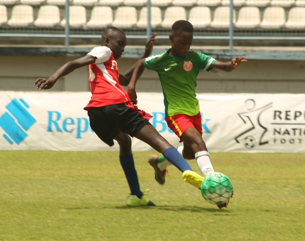 Trendsetter Hawks’ Nieem Taylor moves past the challenge of Jaric Titans’ Kyle James during yesterday’s Under-13 semi-final match. 