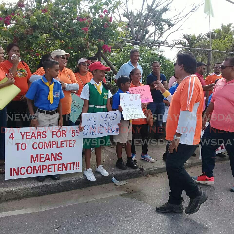 
Parents and children with placards walking from Ramai Trace Hindu School, Penal, to the Ministry of Education San Fernando. Students have been displaced for approximately five years as the completion of their school hangs in limbo. 

Photos: Vashti Singh 