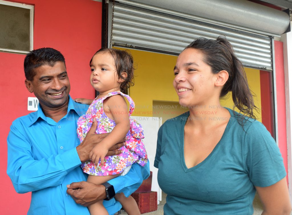  

Siparia Regional Corporation chairman Glenn Ramadharsingh, shares a light hearted moment with Osmaryelin Flores and her daughter Sofia as they wait for transport to move them to their new home from Irwin Park, Siparia as part of a relocation exercise on Tuesday. PHOTO BY VIDYA THURAB
