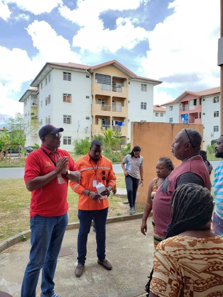 HDC managing director Brent Lyons, left, engages residents of Oropune Gardens, Piarco during an Arouca police community walkabout on Aprill 27.  PHOTO COURTESY HDC