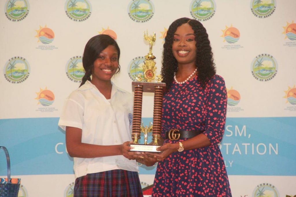 Scarborough Secondary's Kayleigh Lewis, left, collects a trophy after being crowned 2019 Tourism Youth Congress Junior Secretary. The award was presented by Secretary for Tourism Nadine Stewart-Phillips at the Scarborough Library last Friday. 