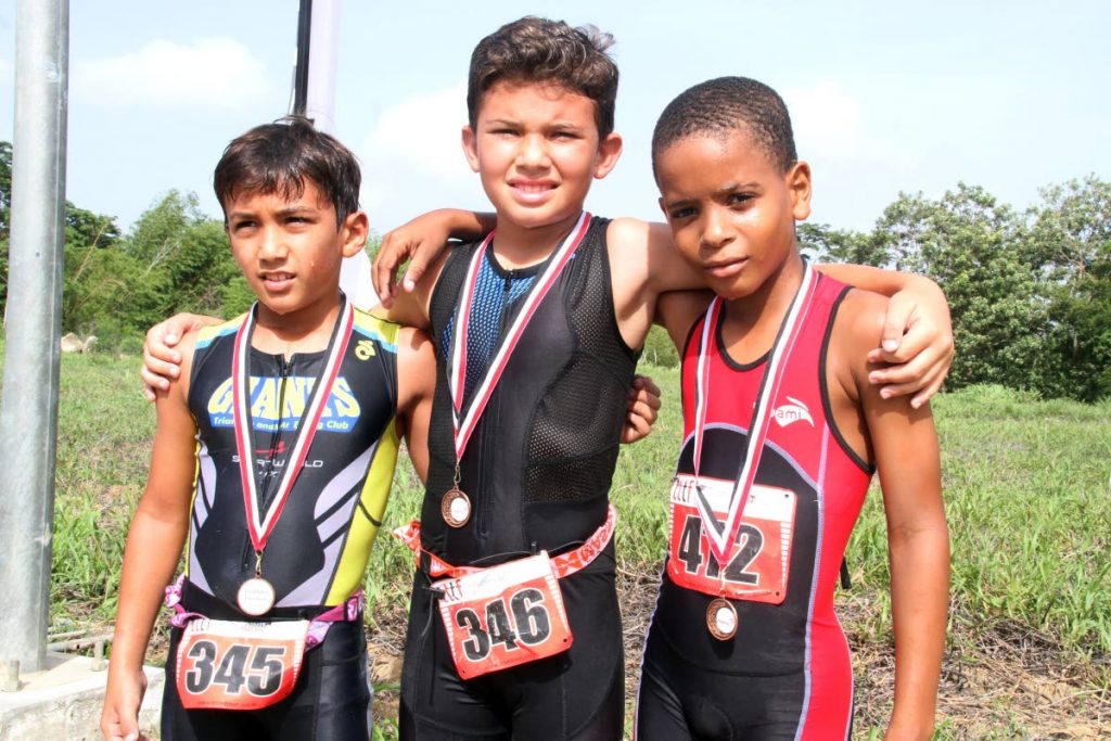 Lucas Shaw (centre), with runner-up Lon Michael Abraham (left) and third-place finisher Josiah Alexander during the recent National Primary Schools Triathlon Championships. 