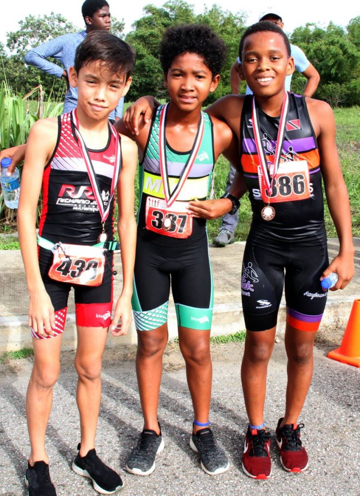 These youngsters display their medals after taking part in the 9-11 TTTF Primary Schools Triathlon championships, held yesterday, at the National Aquatic Centre, Balmain Couve. At left is Tristan Scott (1st place), Macai Dayal (3rd place) and Harland Samuel (2nd).