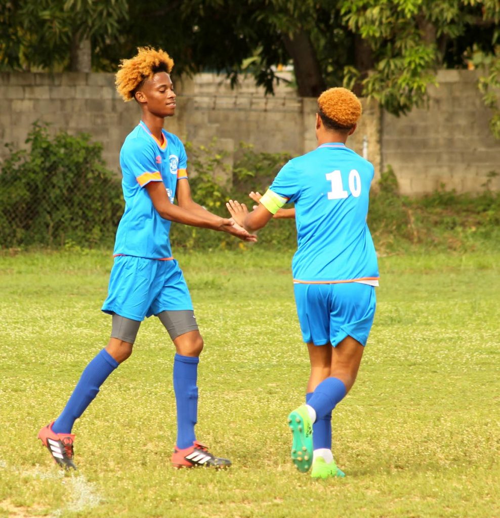 Jeremiah Carimbocas,left, and Tyresse Bernard of the Oropune Police Youth Club celebrate after scoring against the Carapo Police Youth Club, yesterday, during the launch of the Commissioner of Police Football Cup competition, held at the Mickey Trotman Recreation Grounds, Pinto Road, Arima. Oropune PYC won the match 6-0.