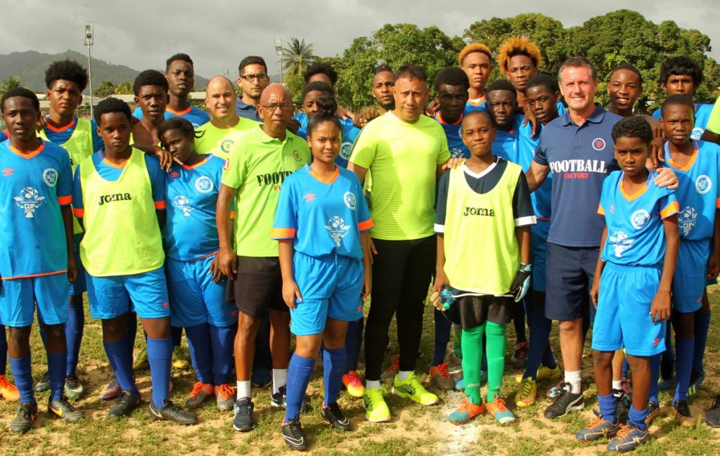 Football Factory’s Terry Fenwick, 2nd from right, Commissioner of Police Gary Griffith,centre, stands with youths of the Carapo Police Youth Club, yesterday, at the launch of the Commissioner of Police Football Cup tournament, held at the Mickey Trotman Recreation Grounds, Pinto Road, Arima.