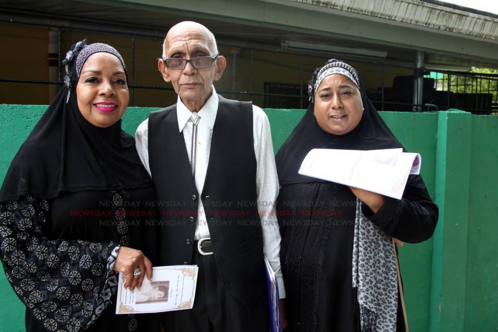 Daughters Valarie Langly, righ,t and Elicia Belcon, left, with brother Torrance Mohammed of the late National Parang Association (NPATT) founder and first president Errol Haronul Mohammed at his funeral at Masjid Al Falaah, Railway Road, Arima, on Monday. PHOTO SUREASH CHOLAI