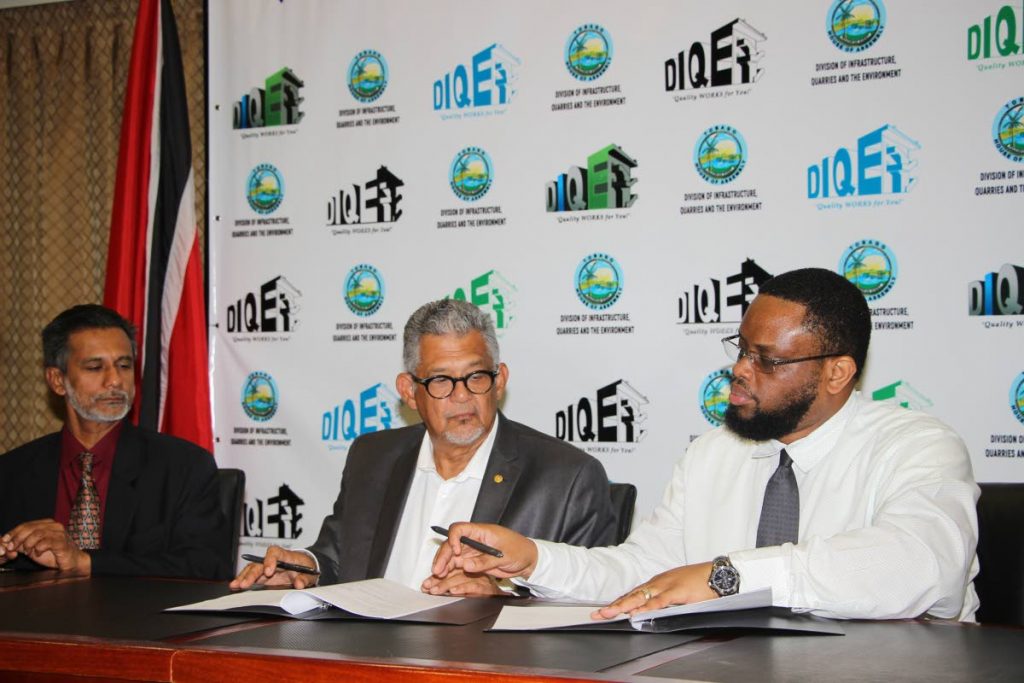 SIGNED: THA’s Department of Infrastructure Quarries and the Environment’s Richie Toppin signs the MoU as PTSC GM Bashir Mohammed, left, and chairman Edwin Gooding look on.