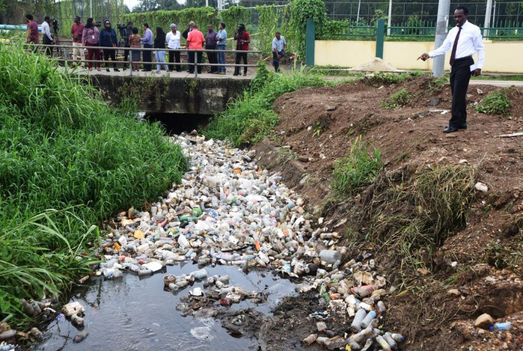 Laventille West MP Fitzgerald Hinds shows the rubbish in the drain during a tour of Servol main drain at Beetham Gardens, Port of Spain, yesterday.