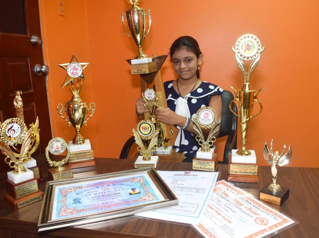 Top SEA student for the Mayaro/ Rio Claro area, Rianne Boodoosingh with her trophies and certificates.