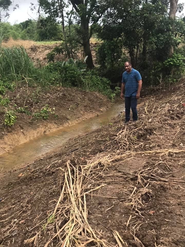 Princes Town Regional Corporation chairman Gowrie Roopnarine examines the work done to Hardbargain and Bonne Terre Trace River yesterday. PHOTO BY SEETA PERSAD
