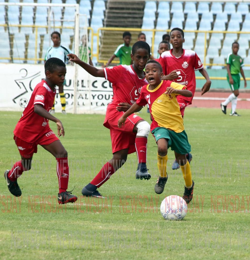 Trendsetter Hawks' Jaseem Celestine, right, runs with the ball in the Under-11 final, of the Republic Bank Cup National Youth League, against Pro Series, earlier today. Celestine was awarded the Most Valubale Player. 