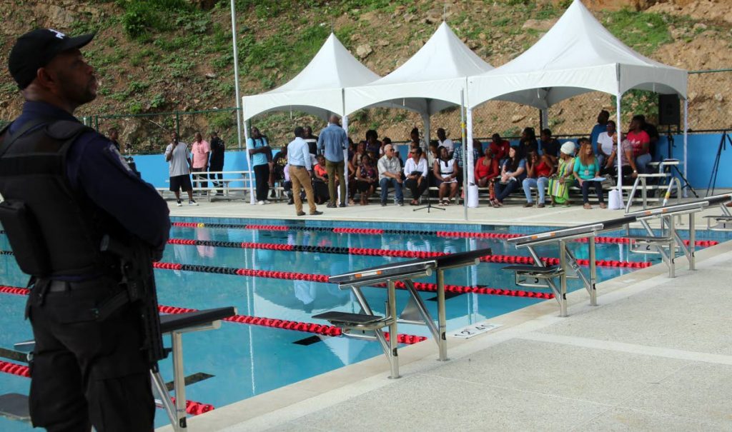 READY FOR USE: A policeman stands guard yesterday during the stakeholders' meeting hosted by Udecott at the Laventille community  swimming pool at Sogren Trace.   PHOTO BY SUREASH CHOLAI