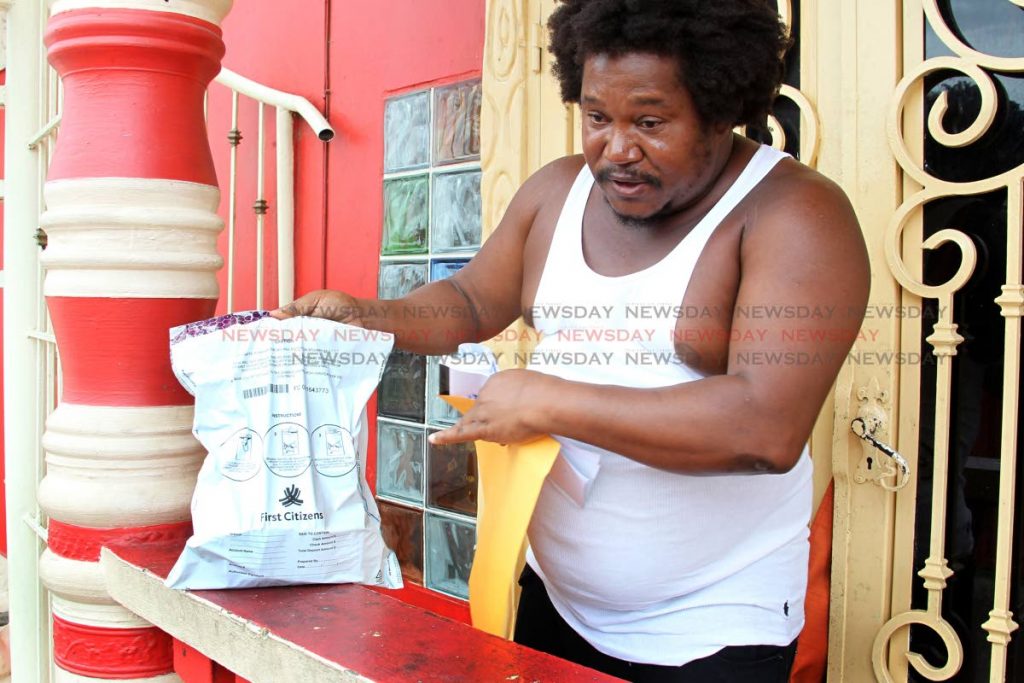 Cedric Burke, shows a bag from commerical bank containing money, as he speaks to Newsday, about crime and corruption, at his Sea Lot residence, Sea Lots. Tuesday, July 9, 2019. Photo by Roger Jacob