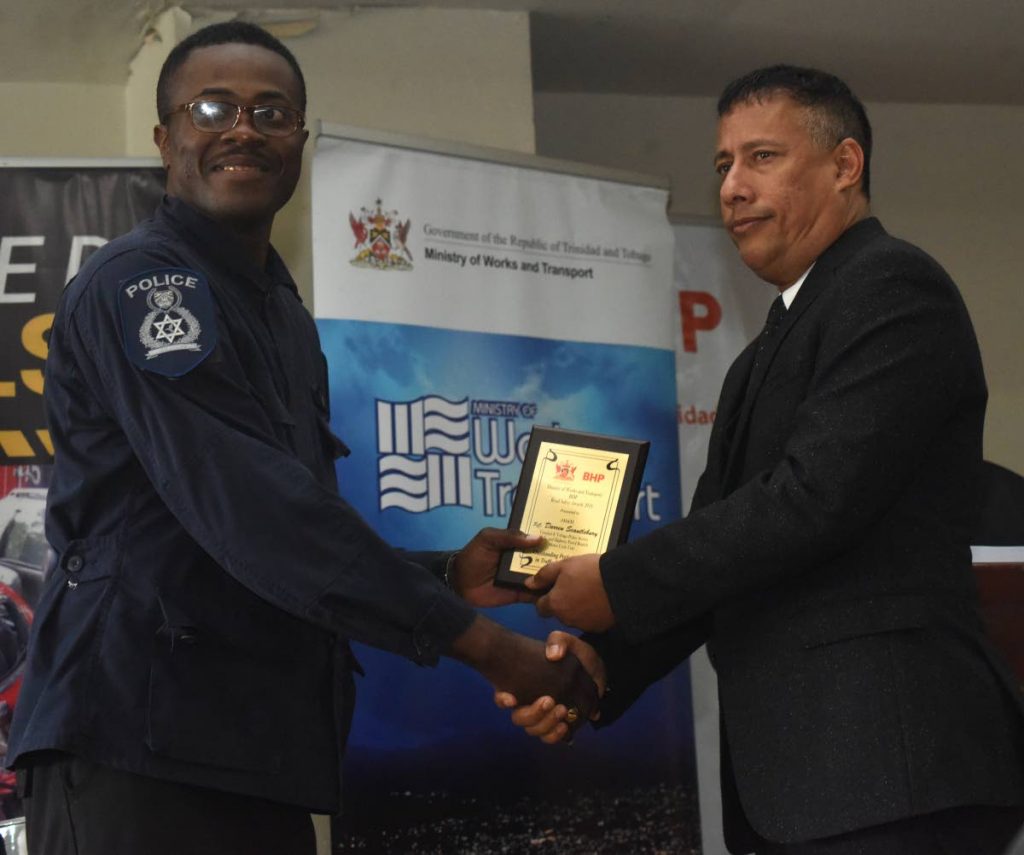 WELL DONE: Police Commissioner Gary Griffith presents an award to PC Darren Scantlebury of the Highway Patrol Branch during a road safety awards ceremony on Wednesday at the Ministry of Works and Transport in Port of Spain. PHOTO BY KERWIN PIERRE
