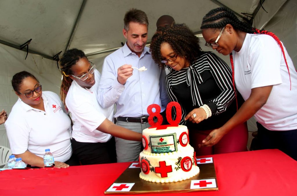 File photo: TT Red Cross president Jill De Bourg, second from right, and international head Ariel Kestens, second from left, cut a cake to celebrate the 80th anniversary of the organisation flanked by Red Cross members at a fair on the Brian Lara Promenade in Port of Spain in July. 