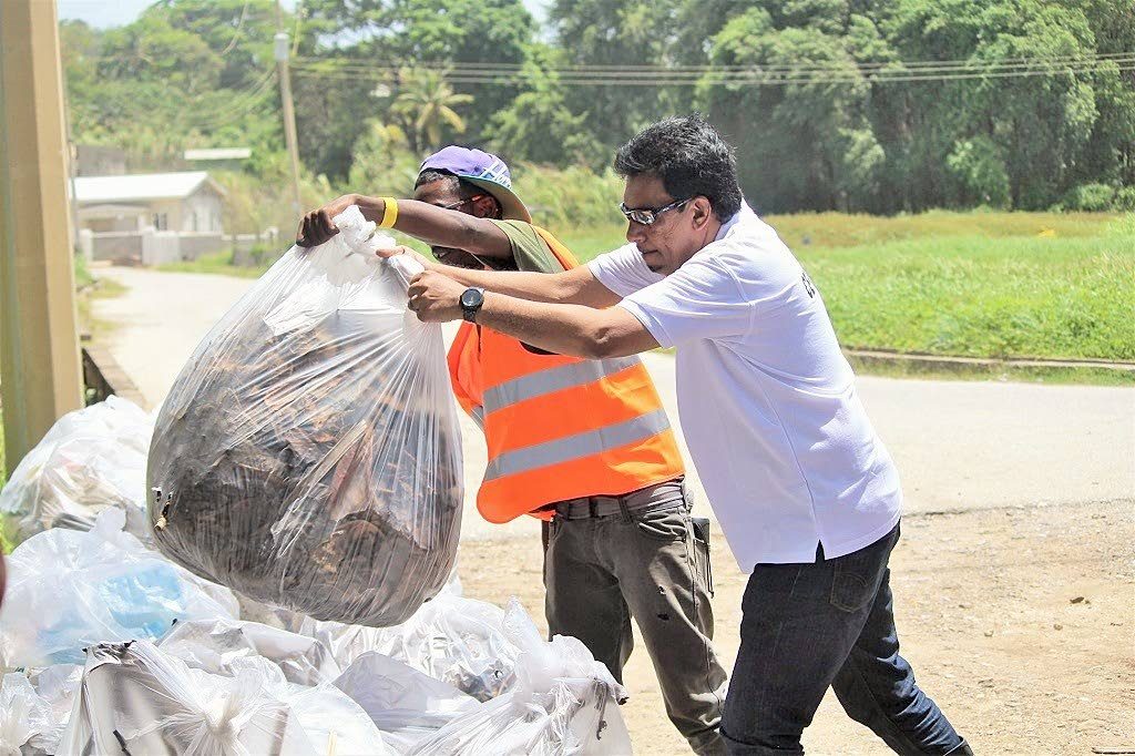 Senator Kazim Hosein, Minister of Rural Development and Local Government assists with the removal of garbage collected during a recent clean-up drive at Manzanilla beach.