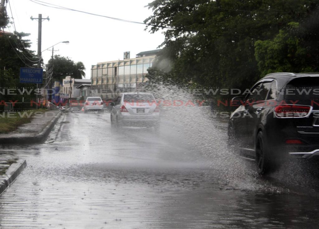 Motorist drive throught flooded streets in Marabella on Wednesday. PHOTO BY VAHSTI SINGH